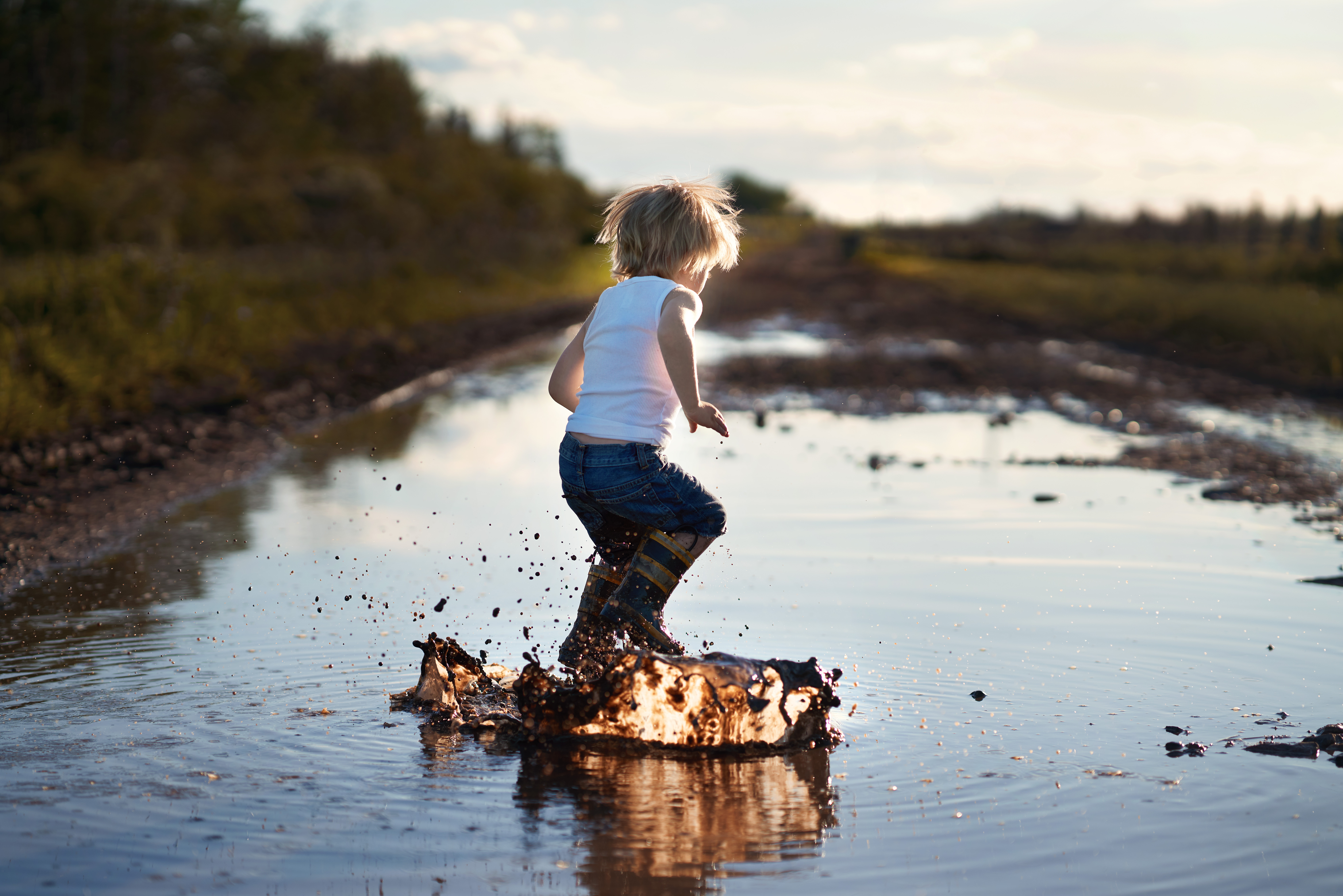 Photo of kid jumping in a puddle